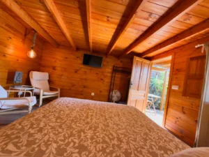 Schlafbereich der Hütte Drago mit offener Tür zur Terrasse